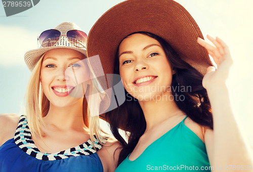 Image of girls in hats on the beach