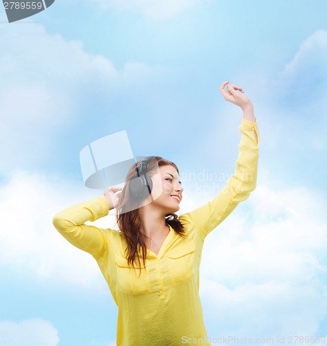 Image of teenage girl sitting on sofa with headphones