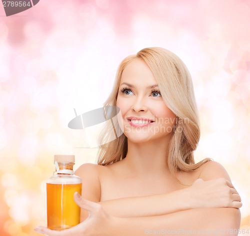 Image of happy woman with oil bottle