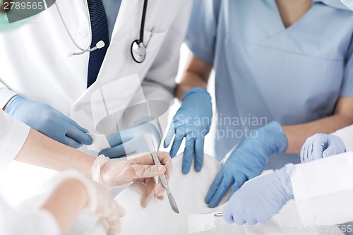 Image of young group of doctors doing operation