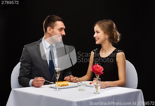 Image of smiling couple eating dessert at restaurant