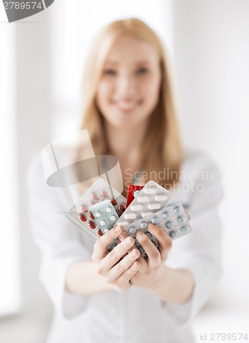 Image of female doctor with packs of pills