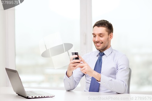 Image of businessman with laptop and smartphone at office