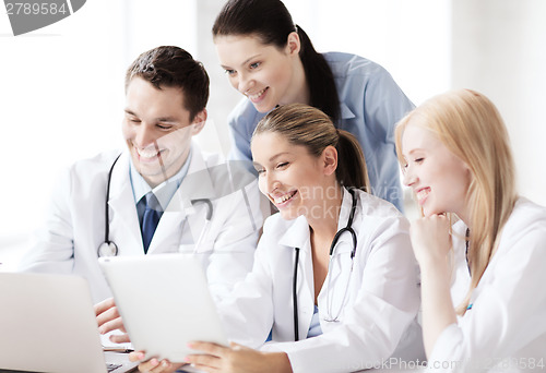 Image of group of doctors looking at tablet pc