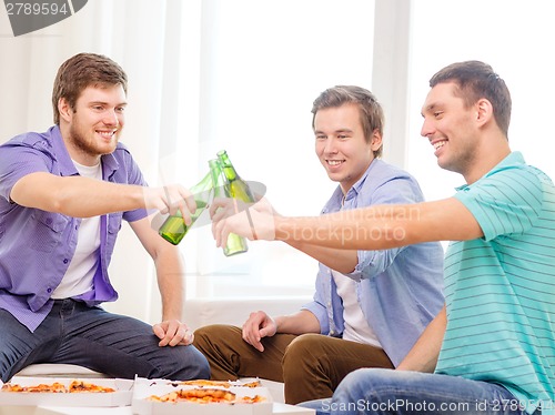 Image of smiling friends with beer and pizza hanging out