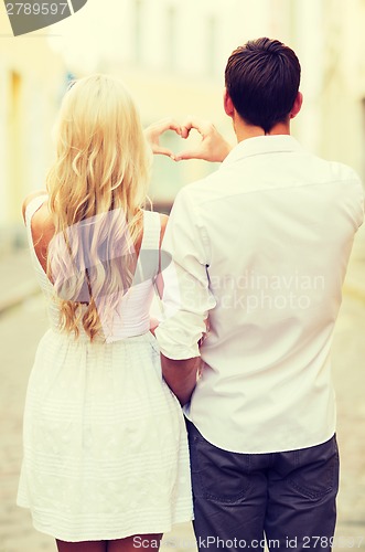 Image of romantic couple in the city making heart shape