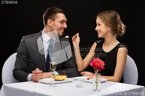 Image of smiling couple eating dessert at restaurant