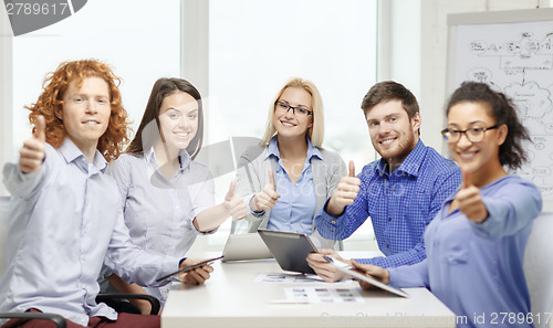 Image of smiling team with table pc and papers working