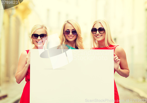 Image of three happy blonde women with blank white board