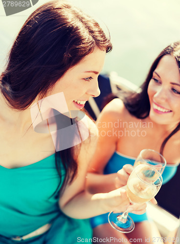 Image of girls with champagne glasses on boat