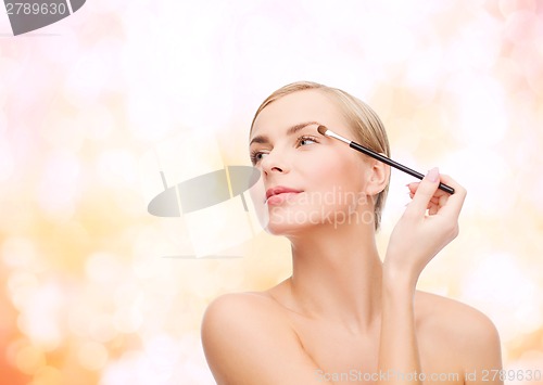 Image of beautiful woman with makeup brush