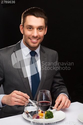 Image of smiling man eating main course
