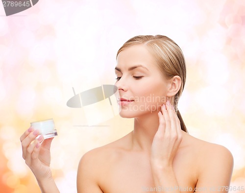 Image of woman applying cream on her skin