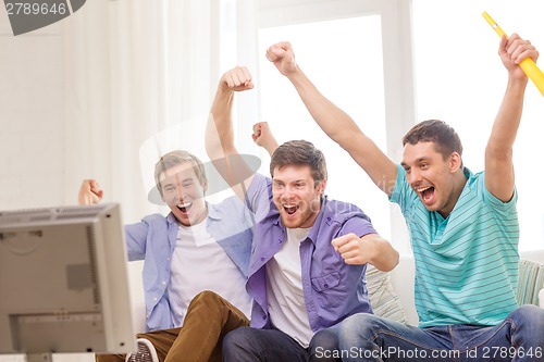 Image of happy male friends with vuvuzela watching sports