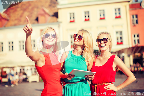 Image of beautiful girls toursits looking into tablet pc