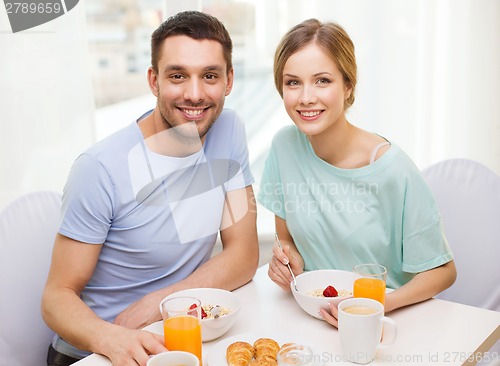 Image of smiling couple having breakfast at home