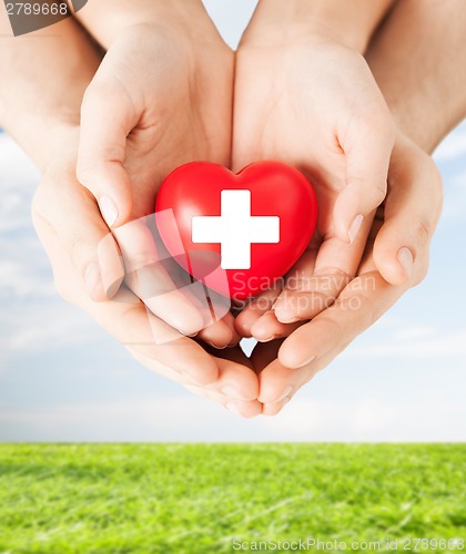 Image of male and female hands with red heart