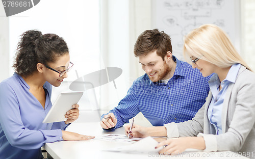 Image of smiling team with table pc and papers working