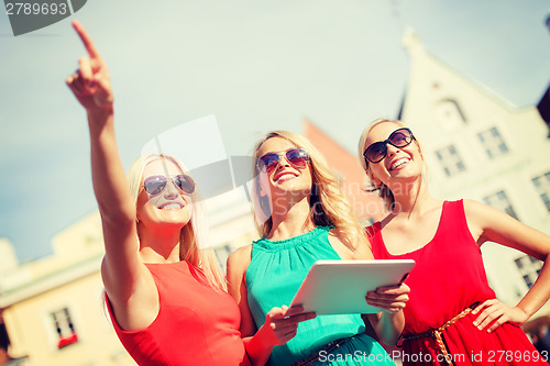 Image of beautiful girls toursits looking into tablet pc