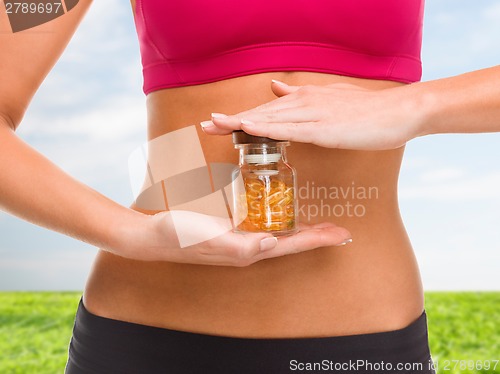 Image of close up of female hands with bottle of capsules