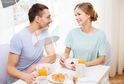 Image of smiling couple having breakfast at home