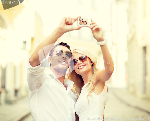 Image of travelling couple taking photo picture with camera