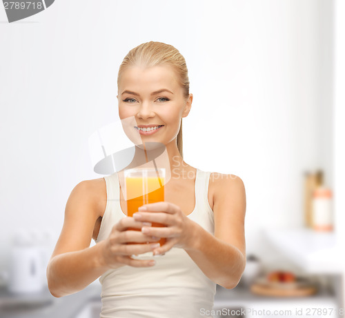 Image of smiling woman holding glass of orange juice