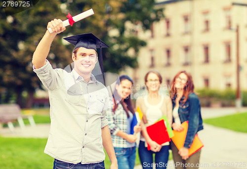 Image of smiling teenage boy in corner-cap with diploma