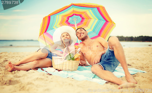 Image of smiling couple sunbathing on the beach