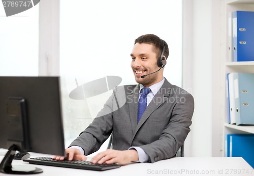 Image of helpline operator with headphones and computer