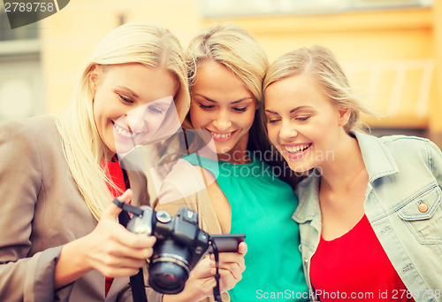 Image of beautiful blonde women with camera in the city