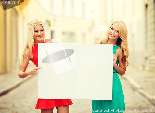 Image of two happy blonde women with blank white board