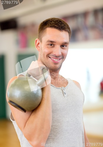 Image of smiling man with kettlebell in gym