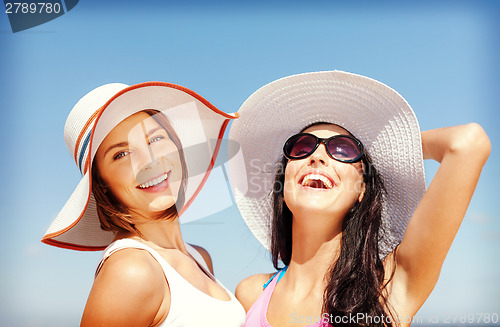 Image of girls in hats on the beach