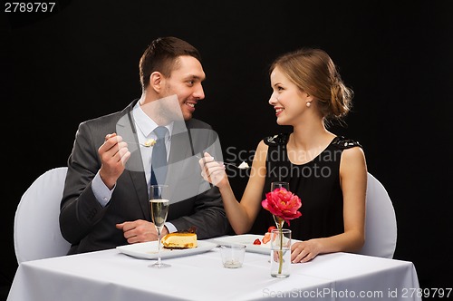 Image of smiling couple eating dessert at restaurant