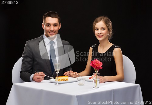 Image of smiling couple eating dessert at restaurant