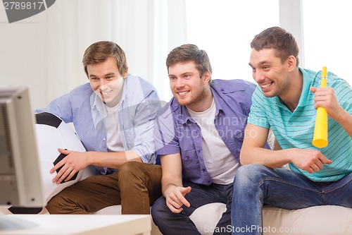 Image of happy male friends with football and vuvuzela