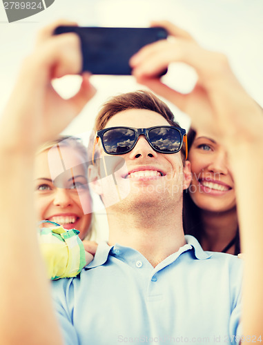 Image of group of friends taking picture with smartphone