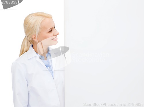 Image of smiling female doctor with white blank board