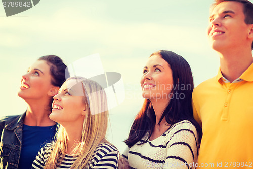 Image of group of friends looking up on the beach