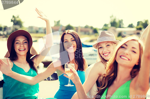 Image of girls with champagne glasses on boat