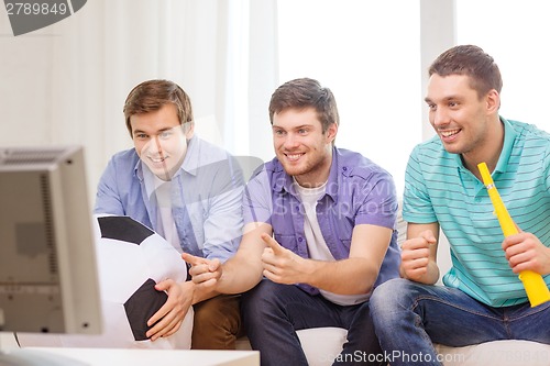 Image of happy male friends with football and vuvuzela