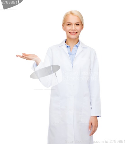 Image of smiling female doctor holding something on hand