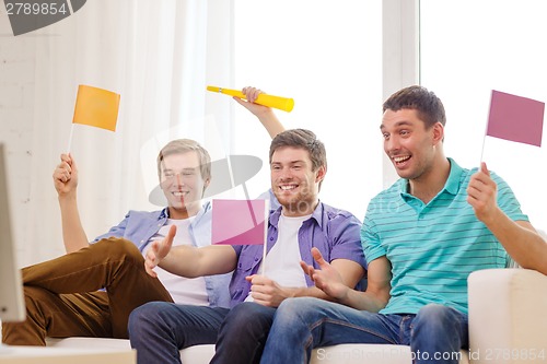 Image of happy male friends with flags and vuvuzela