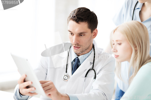 Image of doctor and nurse with patient in hospital