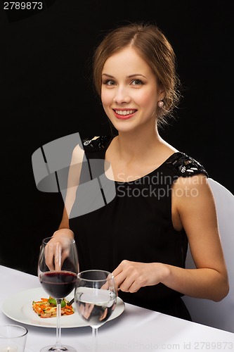 Image of smiling young woman eating main course