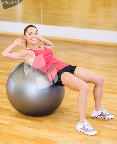 Image of young woman doing exercise on fitness ball