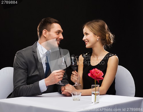 Image of young couple with glasses of wine at restaurant