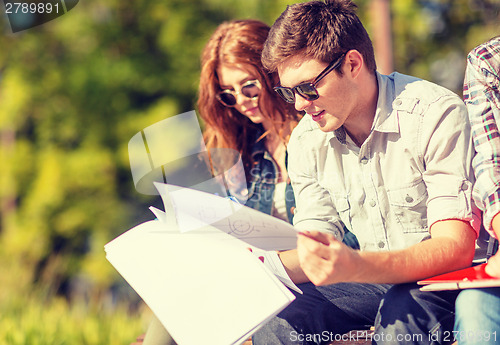 Image of students with books, notebooks, files and folders