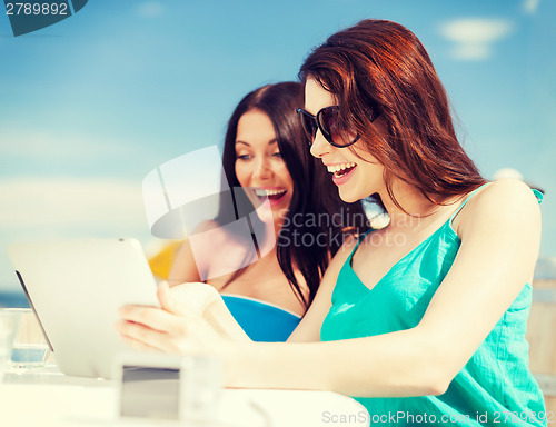 Image of girls looking at tablet pc in cafe